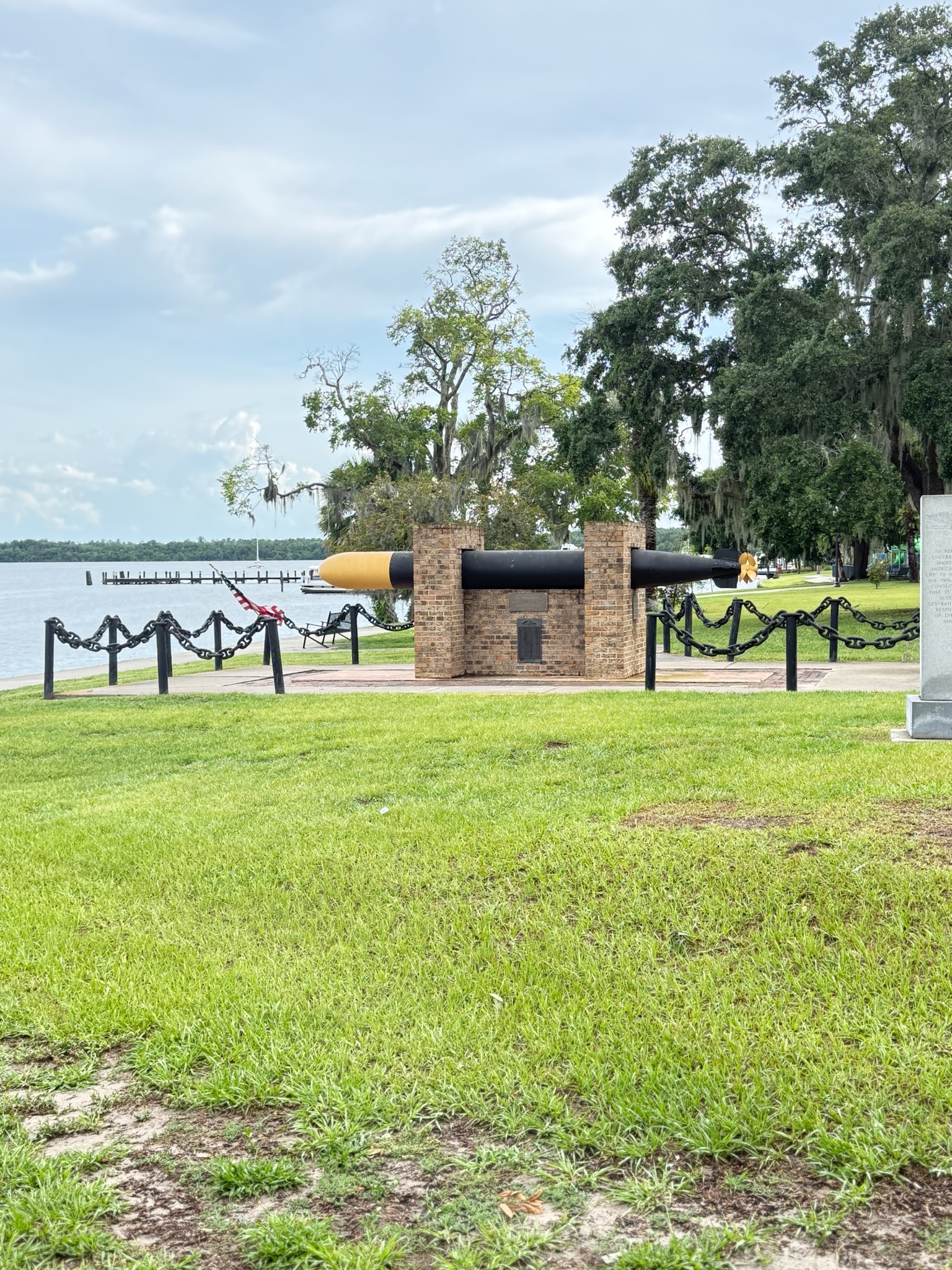 Open lawn in a riverfront park with the bridge over the St. Johns behind it