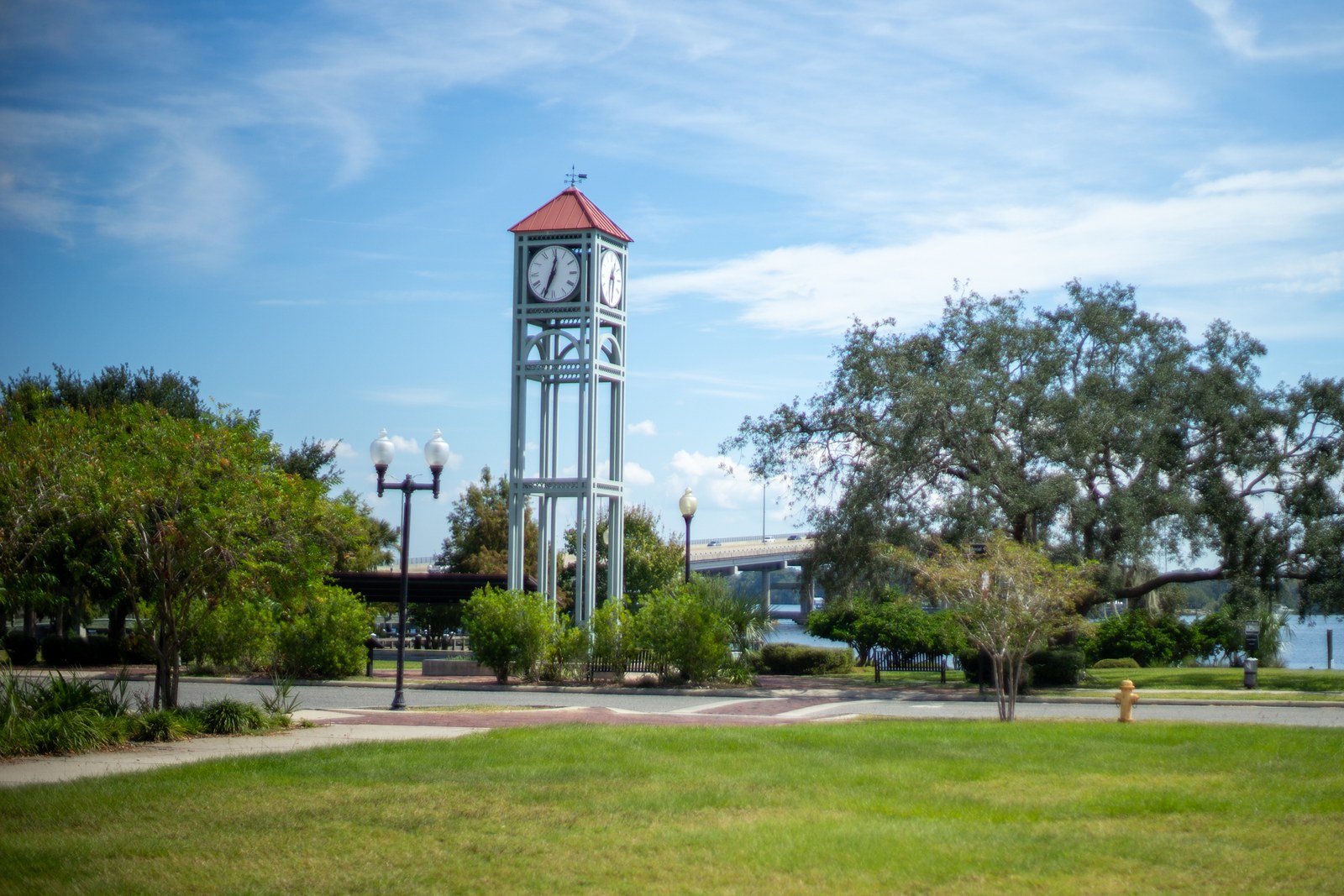 Clock tower and live oaks at the Palatka riverfront with the Memorial Bridge and the St. Johns River in the background
